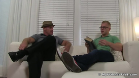 Older guy worshipping the feet of a young blond stud